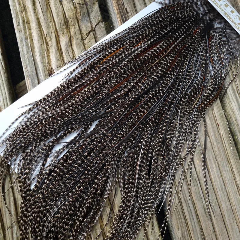 Whiting Heritage Hackles Rooster Saddle in Mixed Colours P Grizzly Variant/Dark Grizzly with a very light Splashing of Natural Black and Furnace  Approx Tying Size 10/12/14-1