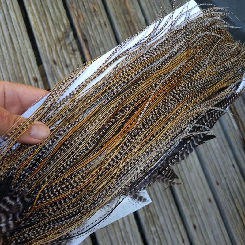 Whiting Pro-Grade Midge Rooster Saddle in Grizzly Variant B Classic Grizzly Splashed with Golden Badger Approx Tying Sizes Few 14 and Stuffed with16/18/20/22 and a few smaller-6